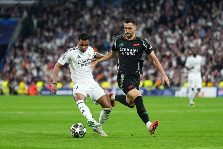 MADRID, SPAIN: Rodrygo of Real Madrid controls the ball whilst under pressure from Mikel Merino of Arsenal during the UEFA Champions League 2024/25...