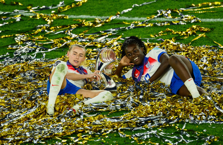 Chloe Kelly and Michelle Agyemang of England celebrate with the UEFA Women's EURO trophy while laying in ticker tape after their team's victory in ...