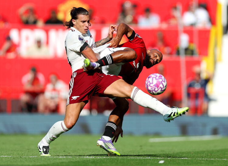 MANCHESTER, ENGLAND - AUGUST 17: Riccardo Calafiori of Arsenal is challenged by Bryan Mbeumo of Manchester United during the Premier League match b...