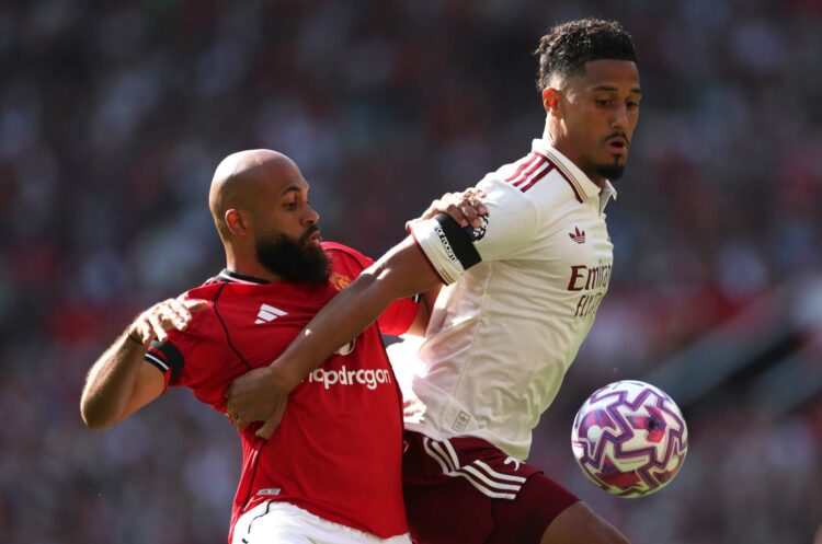 MANCHESTER, ENGLAND - AUGUST 17: William Saliba of Arsenal is challenged by Bryan Mbeumo of Manchester United during the Premier League match betwe...