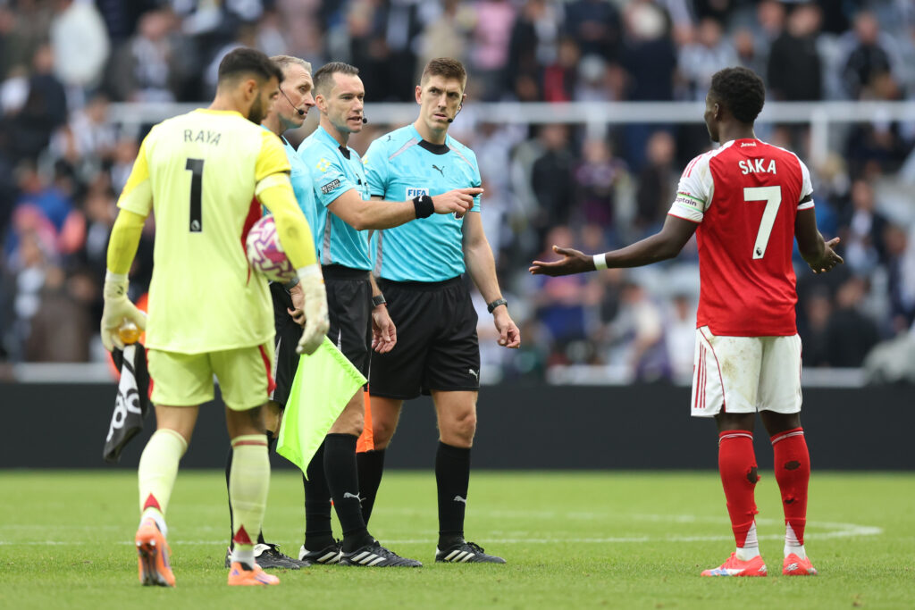 Referee Jarred Gillett speaks with Bukayo Saka of Arsenal at half time during the Premier League match between Newcastle United and Arsenal at St J...