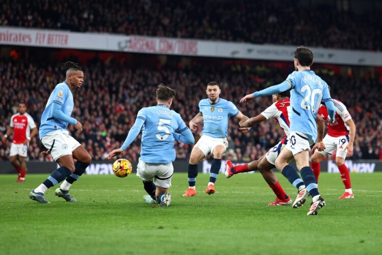 LONDON, ENGLAND: Myles Lewis-Skelly of Arsenal scores his team's third goal whilst under pressure from Manuel Akanji, John Stones and Bernardo Silv...
