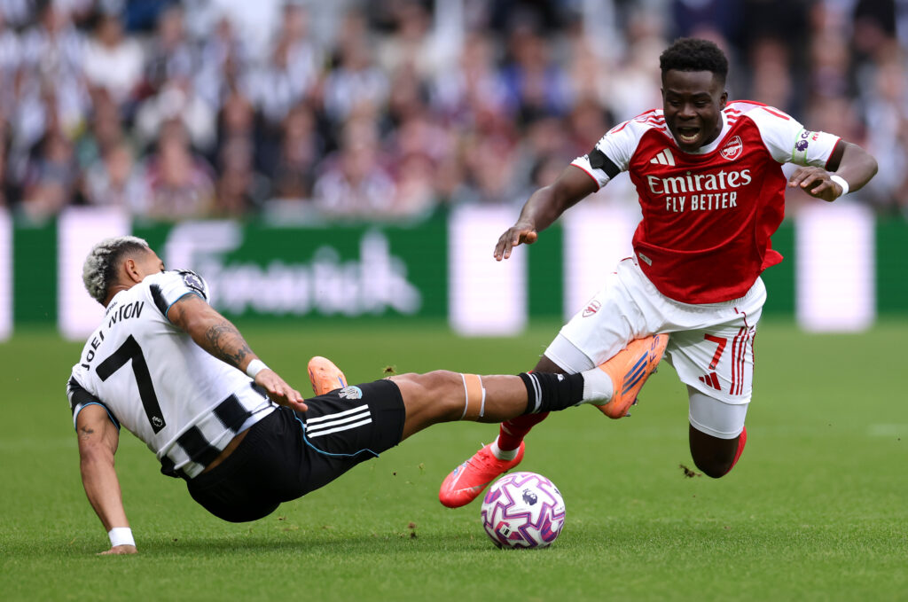 NEWCASTLE UPON TYNE, ENGLAND - SEPTEMBER 28: Bukayo Saka of Arsenal is tackled by Joelinton of Newcastle United during the Premier League match between Newcastle United and Arsenal at St James' Park on September 28, 2025 in Newcastle upon Tyne, England. (Photo by Stu Forster/Getty Images)