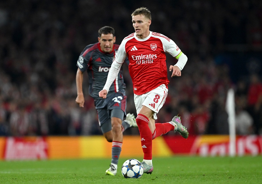 LONDON, ENGLAND: Martin Odegaard of Arsenal runs with the ball whilst under pressure from Santiago Hezze of Olympiacos during the UEFA Champions League 2025/26 League Phase MD2 match between Arsenal FC and Olympiacos FC at Arsenal Stadium on October 01, 2025. (Photo by Mike Hewitt/Getty Images)