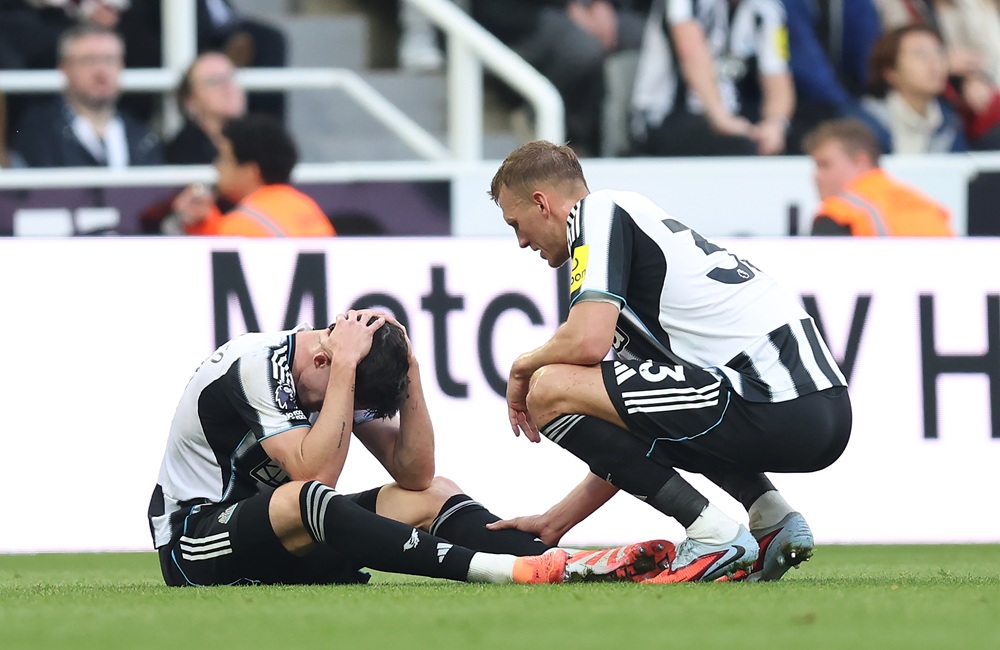 NEWCASTLE UPON TYNE, ENGLAND: Tino Livramento of Newcastle United is consoled by teammate Dan Burn following an injury during the Premier League match between Newcastle United and Arsenal at St James' Park on September 28, 2025. (Photo by George Wood/Getty Images)