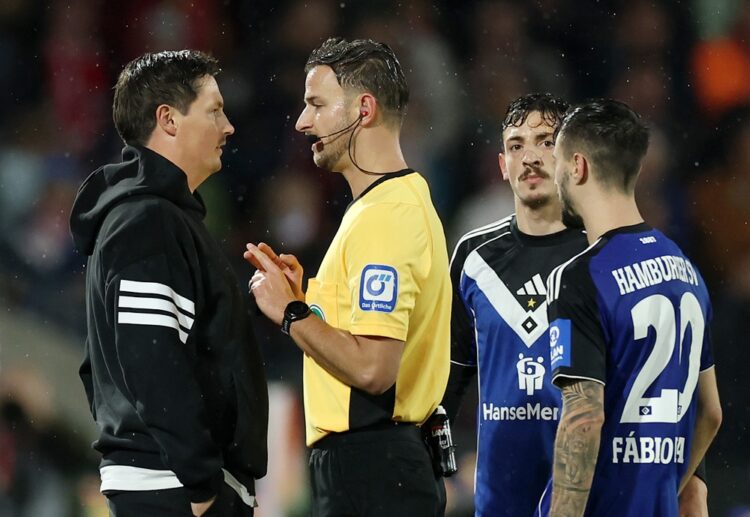 COLOGNE, GERMANY: Merlin Polzin, Head Coach of Hamburger SV, speaks with referee Daniel Schlager after Fabio Vieira of Hamburger SV receives a red ...