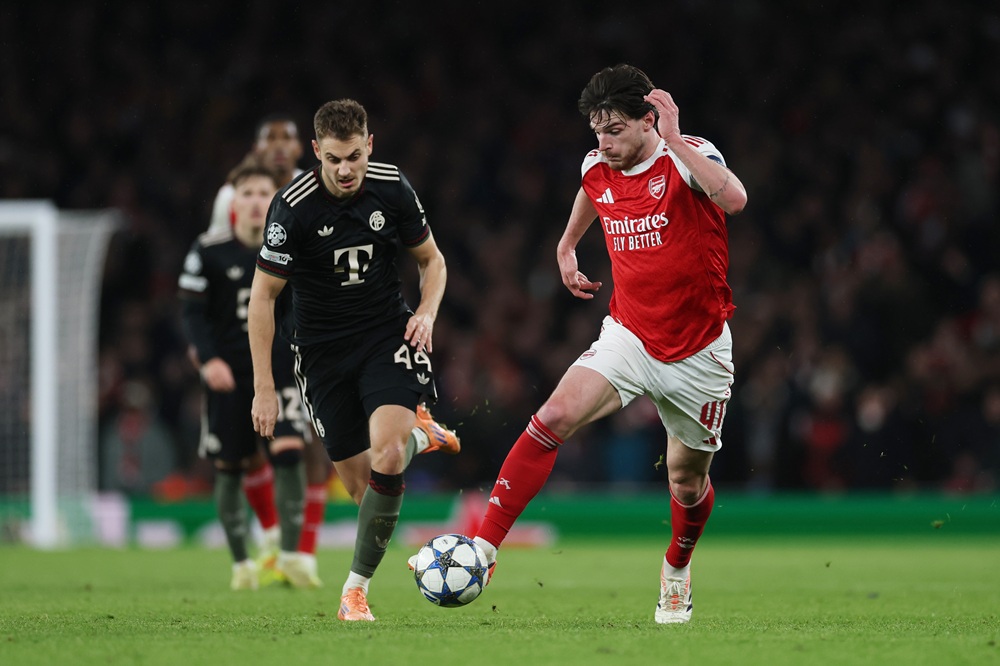 LONDON, ENGLAND: Declan Rice of Arsenal runs with the ball whilst under pressure from Josip Stanisic of Bayern Munich during the UEFA Champions League 2025/26 League Phase MD5 match between Arsenal FC and FC Bayern München at Arsenal Stadium on November 26, 2025. (Photo by Richard Heathcote/Getty Images)