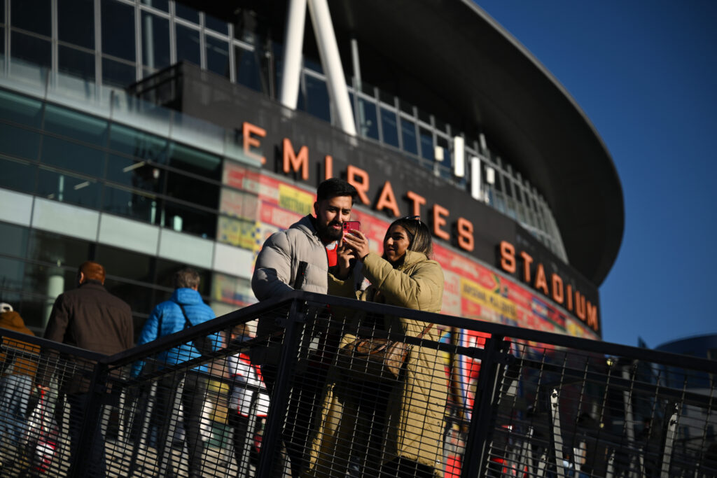 LONDON, ENGLAND - FEBRUARY 02: Fans of Arsenal look at a mobile phone as they gather on the outside of the stadium prior to the Premier League match between Arsenal FC and Manchester City FC at Emirates Stadium on February 02, 2025 in London, England. (Photo by Justin Setterfield/Getty Images)