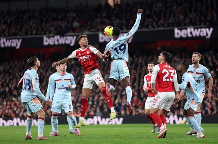 LONDON, ENGLAND: Ben White of Arsenal battles for an aerial ball against Dango Ouattara of Brentford during the Premier League match between Arsena...
