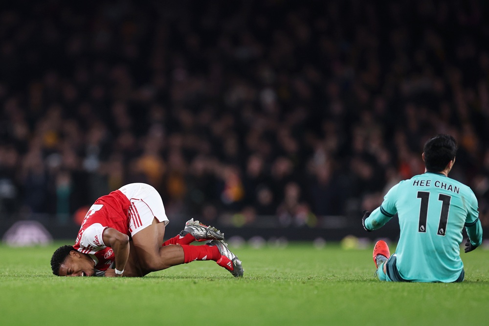 LONDON, ENGLAND: Myles Lewis-Skelly of Arsenal lies on the ground in pain after being fouled by Hwang Hee-Chan of Wolverhampton Wanderers during the Premier League match between Arsenal and Wolverhampton Wanderers at Emirates Stadium on December 13, 2025. (Photo by Julian Finney/Getty Images)