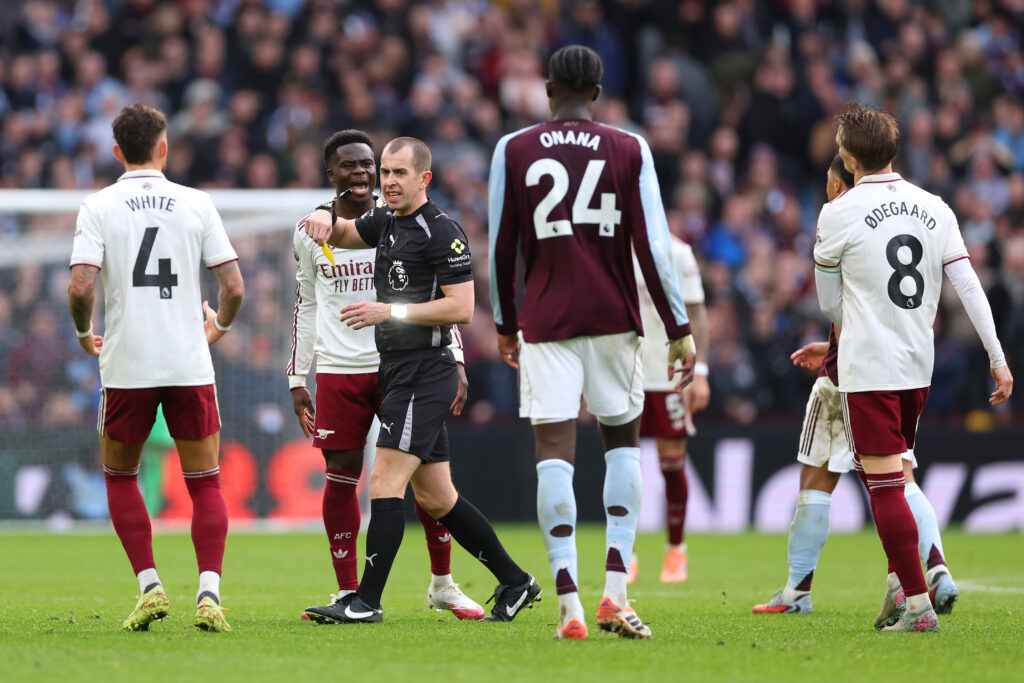 BIRMINGHAM, ENGLAND - DECEMBER 06: Bukayo Saka of Arsenal (2L) reacts to being shown a yellow card by Referee, Peter Bankes, during the Premier League match between Aston Villa and Arsenal at Villa Park on December 06, 2025 in Birmingham, England. (Photo by Alex Pantling/Getty Images)