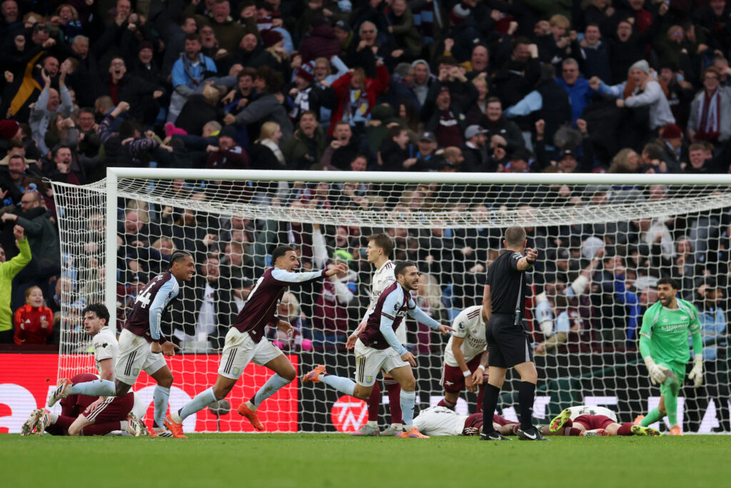 BIRMINGHAM, ENGLAND - DECEMBER 06: Emi Buendia of Aston Villa (R) celebrates scoring his team's second goal with teammate Morgan Rogers (C) and Boubacar Kamara (L) as Arsenal players looks dejected look during the Premier League match between Aston Villa and Arsenal at Villa Park on December 06, 2025 in Birmingham, England. (Photo by Alex Pantling/Getty Images)
