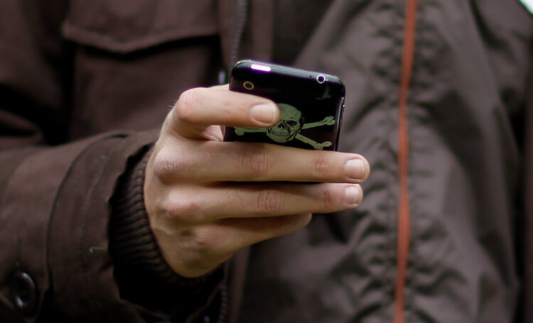 A team member of St. Pauli writes a message on his mobile phone during the Bundesliga match between Borussia Dortmund and FC St. Pauli