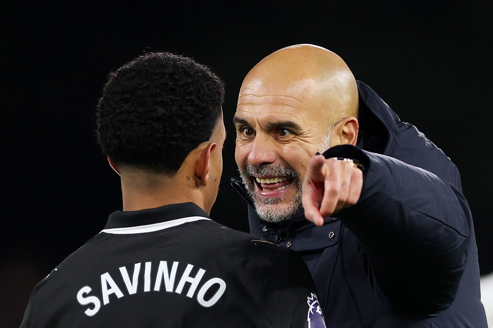 LONDON, ENGLAND: Pep Guardiola, Manager of Manchester City, speaks to Savinho of Manchester City after the team's victory in the Premier League match between Fulham and Manchester City at Craven Cottage on December 02, 2025. (Photo by Justin Setterfield/Getty Images)