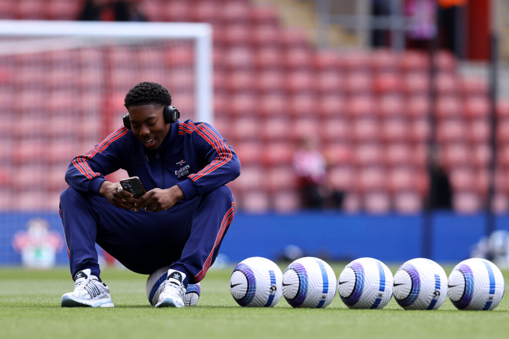 SOUTHAMPTON, ENGLAND - MAY 25: Myles Lewis-Skelly of Arsenal sits on top of a Nike Flight Match Ball and checks his phone prior to the Premier League match between Southampton FC and Arsenal FC at St Mary's Stadium on May 25, 2025 in Southampton, England. (Photo by Charlie Crowhurst/Getty Images)