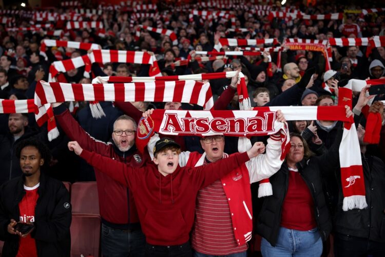 Fans of Arsenal show their support as they hold scarves prior to the Premier League match between Arsenal and Manchester United at Emirates Stadium...