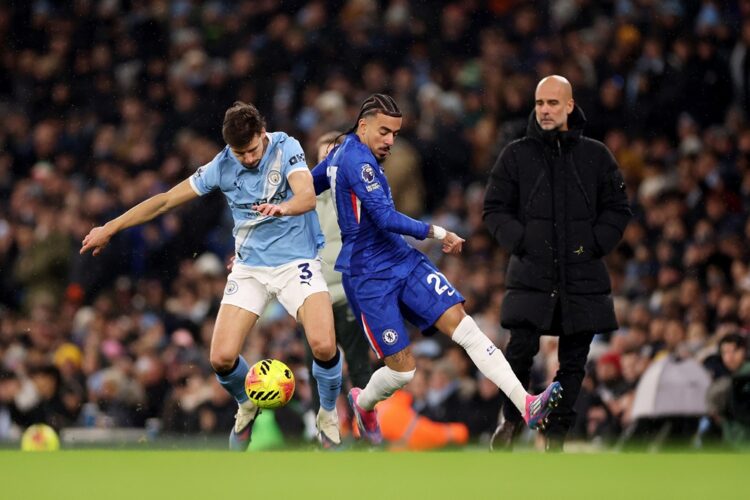 Ruben Dias of Manchester City and Malo Gusto of Chelsea battle for possession during the Premier League match between Manchester City and Chelsea a...