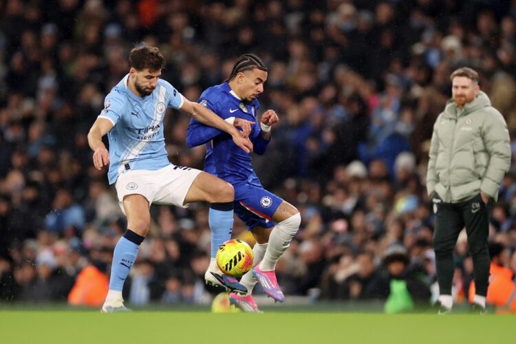 Ruben Dias of Manchester City and Malo Gusto of Chelsea battle for possession during the Premier League match between Manchester City and Chelsea a...