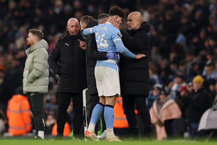 Pep Guardiola, Manager of Manchester City, speaks to Josko Gvardiol of Manchester City as he leaves the pitch after getting injured during the Prem...