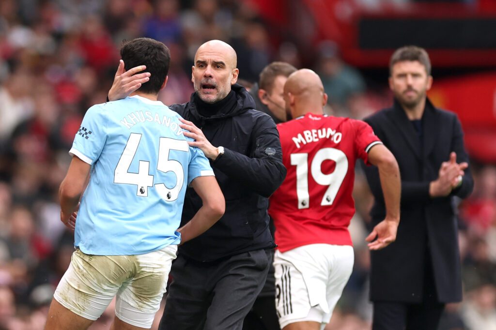 MANCHESTER, ENGLAND - JANUARY 17: Pep Guardiola speaks to Abdukodir Khusanov of Manchester City during the Premier League match between Manchester United and Manchester City at Old Trafford on January 17, 2026 in Manchester, England. (Photo by Carl Recine/Getty Images)