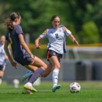 Cecily Wellesley-Smith squares up to a German player in an u19 friendly while playing for England
