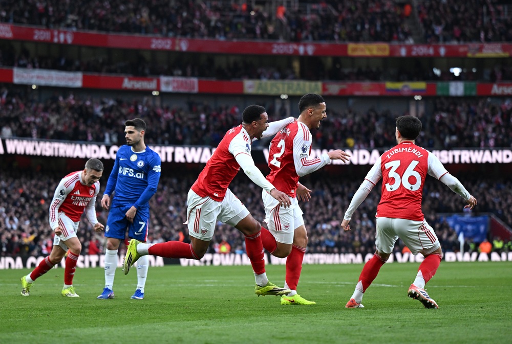 William Saliba of Arsenal celebrates with teammates Gabriel Magalhaes and Martin Zubimendi after scoring during the Premier League match between Ar...