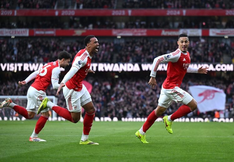 William Saliba of Arsenal celebrates with teammates Gabriel Magalhaes and Martin Zubimendi after scoring during the Premier League match between Ar...