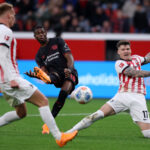LEVERKUSEN, GERMANY - OCTOBER 26: Christian Kofane of Bayer Leverkusen shoots whilst under pressure from Lukas Kubler of SC Freiburg during the Bundesliga match between Bayer 04 Leverkusen and SC Freiburg at BayArena on October 26, 2025 in Leverkusen, Germany. (Photo by Dean Mouhtaropoulos/Getty Images)