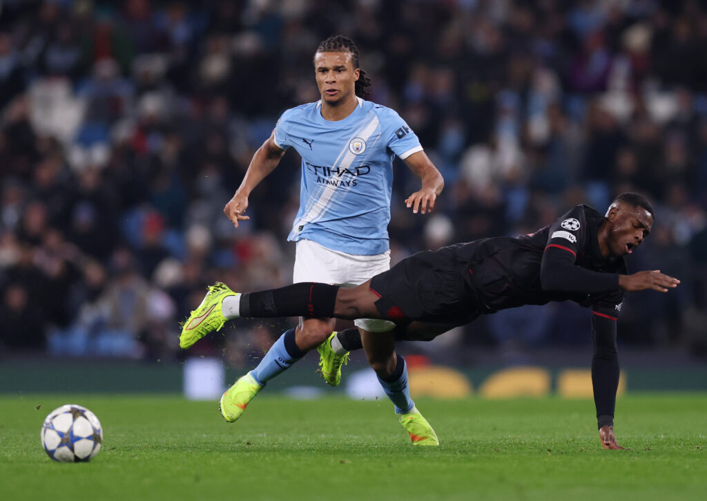 MANCHESTER, ENGLAND - NOVEMBER 25: Christian Kofane of Bayer Leverkusen is challenged by Nathan Ake of Manchester City during the UEFA Champions League 2025/26 League Phase MD5 match between Manchester City and Bayer 04 Leverkusen at City of Manchester Stadium on November 25, 2025 in Manchester, England. (Photo by Carl Recine/Getty Images)