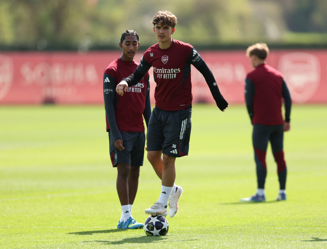 Max Dowman stands on the ball during Arsenal training. Marli Salmon stands behind him. They are both wearing Arsenal training kits of a deep red an...