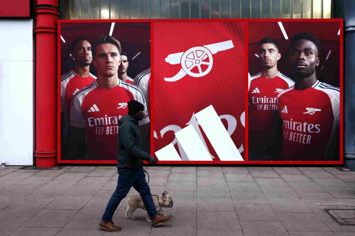 LONDON, ENGLAND - JANUARY 18: A man walks his dog outside the stadium in-front of an Adidas advert featuring Martin Odegaard and Bukayo Saka prior ...
