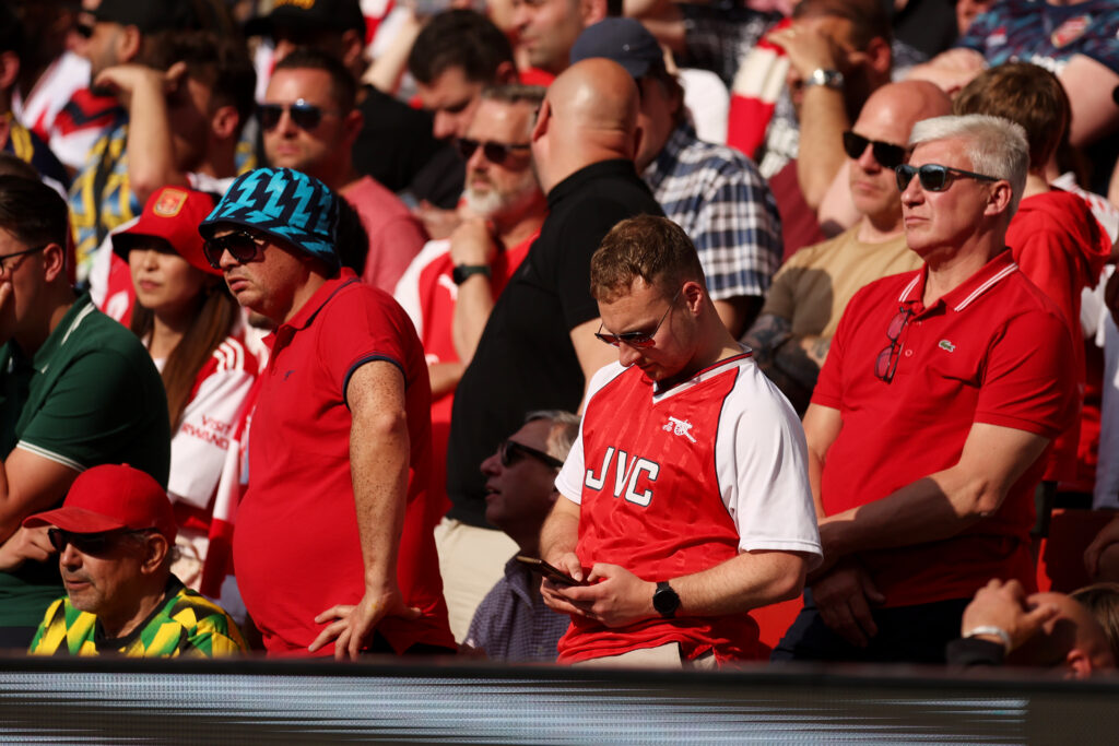 LONDON, ENGLAND - MAY 19: Arsenal fans check their phones during the Premier League match between Arsenal FC and Everton FC at Emirates Stadium on May 19, 2024 in London, England. (Photo by Julian Finney/Getty Images)