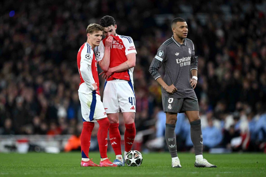 Declan Rice uses his shirt to cover his mouth as he talks to Martin Odegaard