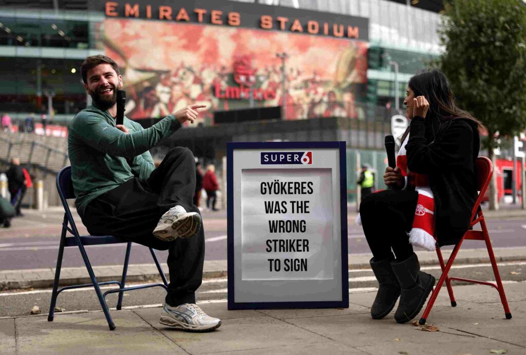 LONDON, ENGLAND - OCTOBER 04: Fans are interviewed by Sky Sports next to a sign reading "Gyokeres was the wrong strike to sign" prior to the Premier League match between Arsenal and West Ham United at Emirates Stadium on October 04, 2025 in London, England. (Photo by Alex Pantling/Getty Images)