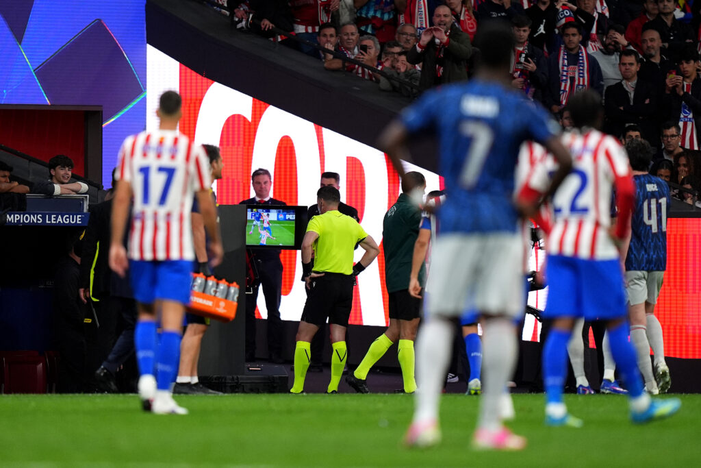 Referee Danny Makkelie checks the VAR screen before overturning a penalty to Arsenal for a foul by David Hancko of Atletico de Madrid