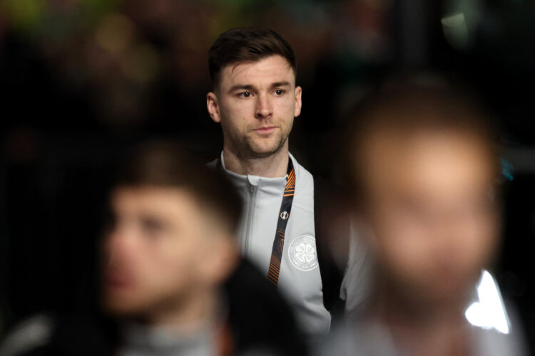Kieran Tierney stands in the background as his teammates are blurred out in front of him