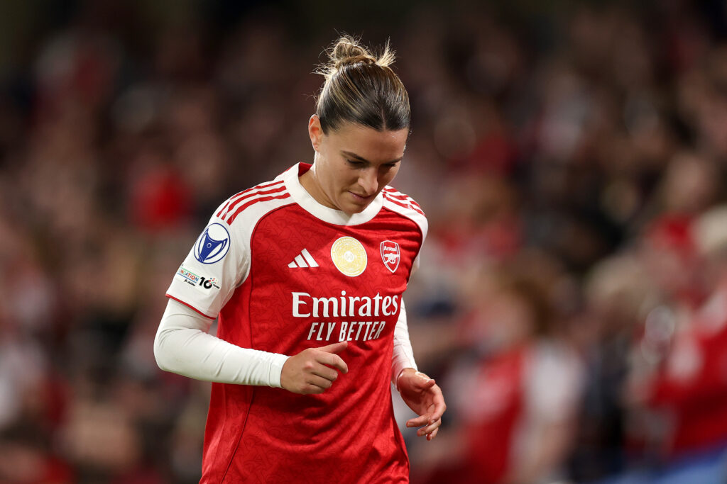 Steph Catley in an Arsenal kit jogs with her head down