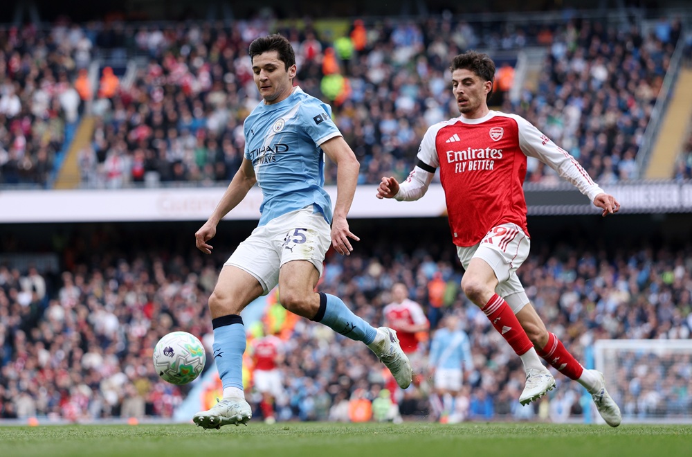 Abdukodir Khusanov of Manchester City controls the ball while under pressure from Kai Havertz of Arsenal during the Premier League match between Ma...