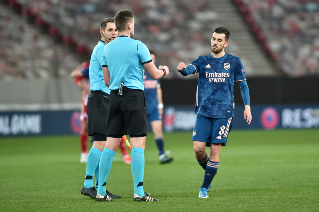 PIRAEUS, GREECE - MARCH 11: Dani Ceballos of Arsenal interacts with Referee, Daniel Siebert after the UEFA Europa League Round of 16 First Leg match between Olympiacos and Arsenal at Karaiskakis Stadium on March 11, 2021 in Piraeus, Greece. Sporting stadiums around Europe remain under strict restrictions due to the Coronavirus Pandemic as Government social distancing laws prohibit fans inside venues resulting in games being played behind closed doors. (Photo by Milos Bicanski/Getty Images)