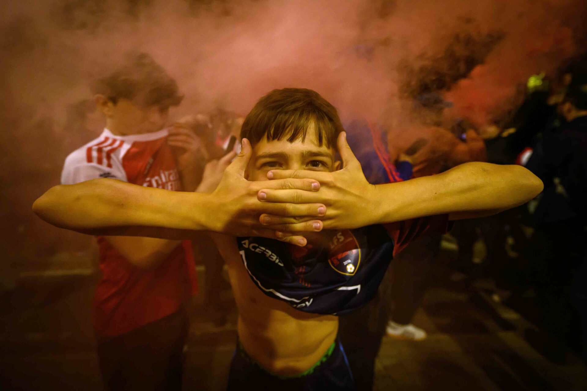 LONDON, ENGLAND - MAY 19: A young boy poses for a photo in the smoke from a flare as fans celebrate outside Emirates Stadium as Arsenal take the Premier League title on May 19, 2026 in London, England. Arsenal have won their first Premier League title in 22 years after Manchester City drew 1-1 with Bournemouth. (Photo by Leon Neal/Getty Images)