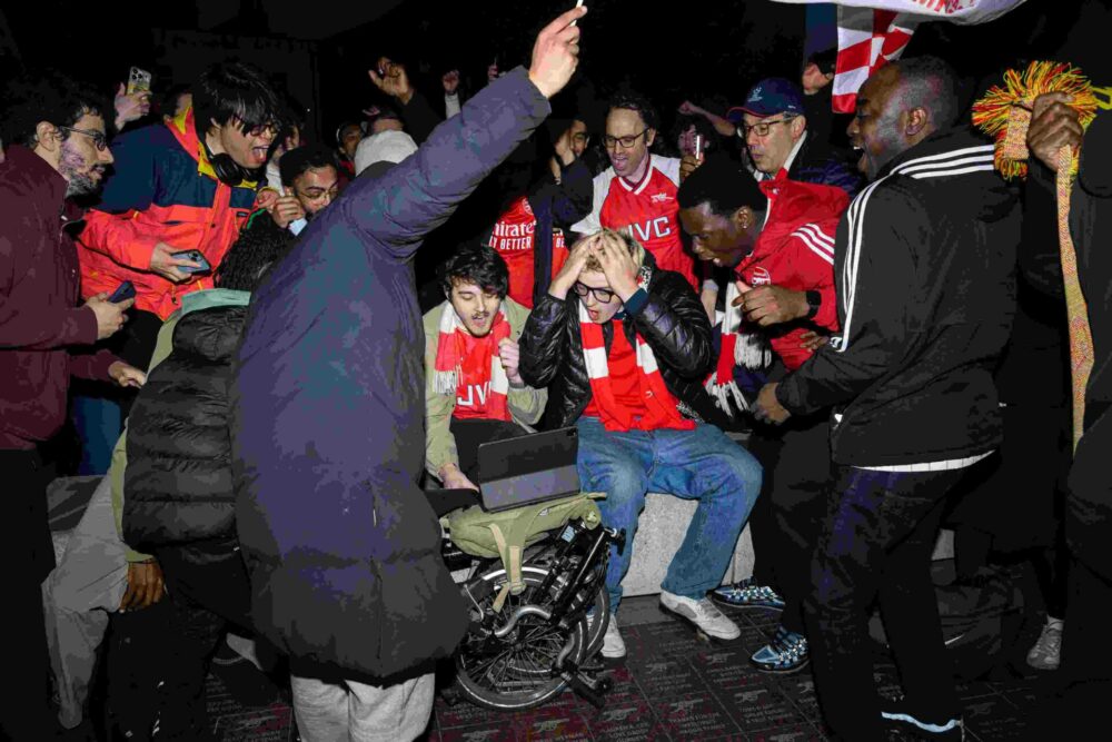 Arsenal fans anxiously watch a screen showing the Manchester City vs AFC Bournemouth match outside Emirates Stadium on May 19, 2026 in London, England. Arsenal have won their first Premier League title in 22 years after Manchester City drew 1-1 with Bournemouth.