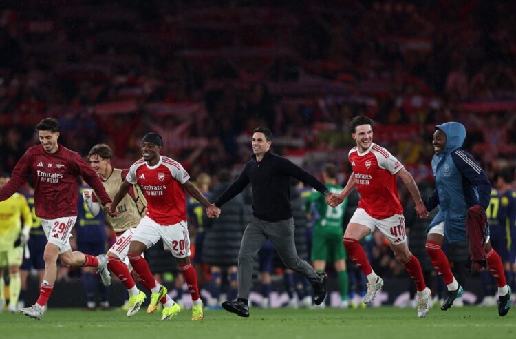 Mikel Arteta, Manager of Arsenal, celebrates progressing to the final of the UEFA Champions League 2025/26 with Noni Madueke and Declan Rice of Ars...