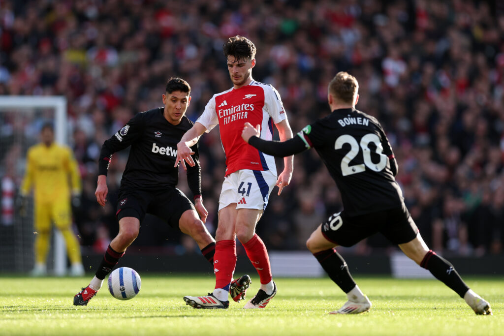 Declan Rice of Arsenal passes the ball under pressure from Jarrod Bowen of West Ham United during the Premier League match between Arsenal FC and West Ham United FC at Emirates Stadium on February 22, 2025 in London, England.