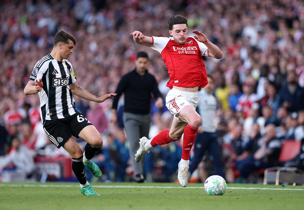 Declan Rice of Arsenal runs with the ball under pressure from Lewis Miley of Newcastle United during the Premier League match between Arsenal and Newcastle United at Emirates Stadium on April 25, 2026 in London, England. (Photo by Richard Heathcote/Getty Images)
