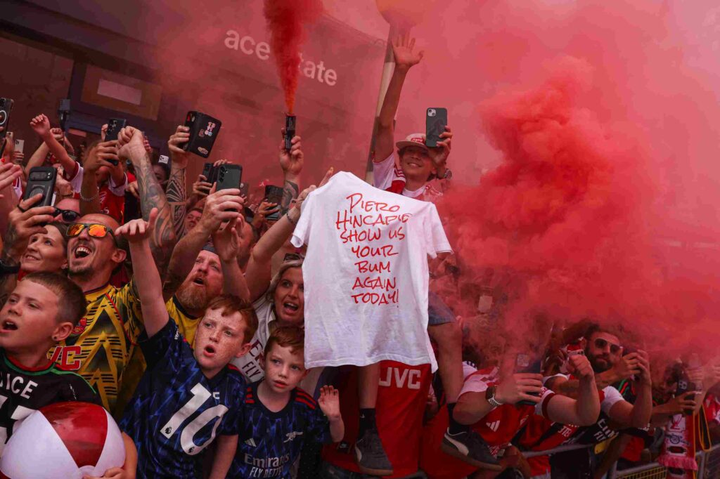 A shirt reading 'Piero Hincapie show us your bum again today!' is displayed by fans during the Arsenal Trophy Parade on May 31, 2026 in Islington, England. Arsenal clinched their first Premier League title in 22 years earlier this month.