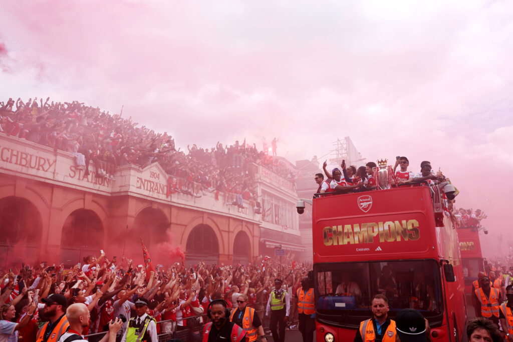A general view as the Open Top Bus passes the entrance to Highbury Station as fans celebrate during the Arsenal Trophy Parade on May 31, 2026 in Islington, England. Arsenal clinched their first Premier League title in 22 years earlier this month
