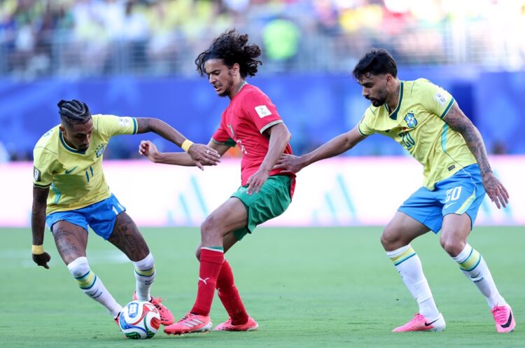 Ayyoub Bouaddi #6 of Morocco is challenged by Raphinha #11 and Lucas Paqueta #20 of Brazil during the FIFA World Cup 2026 Group C match between Bra...