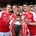 Viktor Gyoekeres, Martin Odegaard and Christian Norgaard of Arsenal pose for a photograph the Premier League trophy as players of Arsenal celebrate, as they are crowned the Champions of the Premier League for the 2025/26 Season, after the Premier League match between Crystal Palace and Arsenal