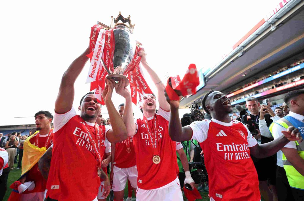 Jurrien Timber, Declan Rice of Arsenal and Bukayo Saka of Arsenal celebrate with the Premier League trophy