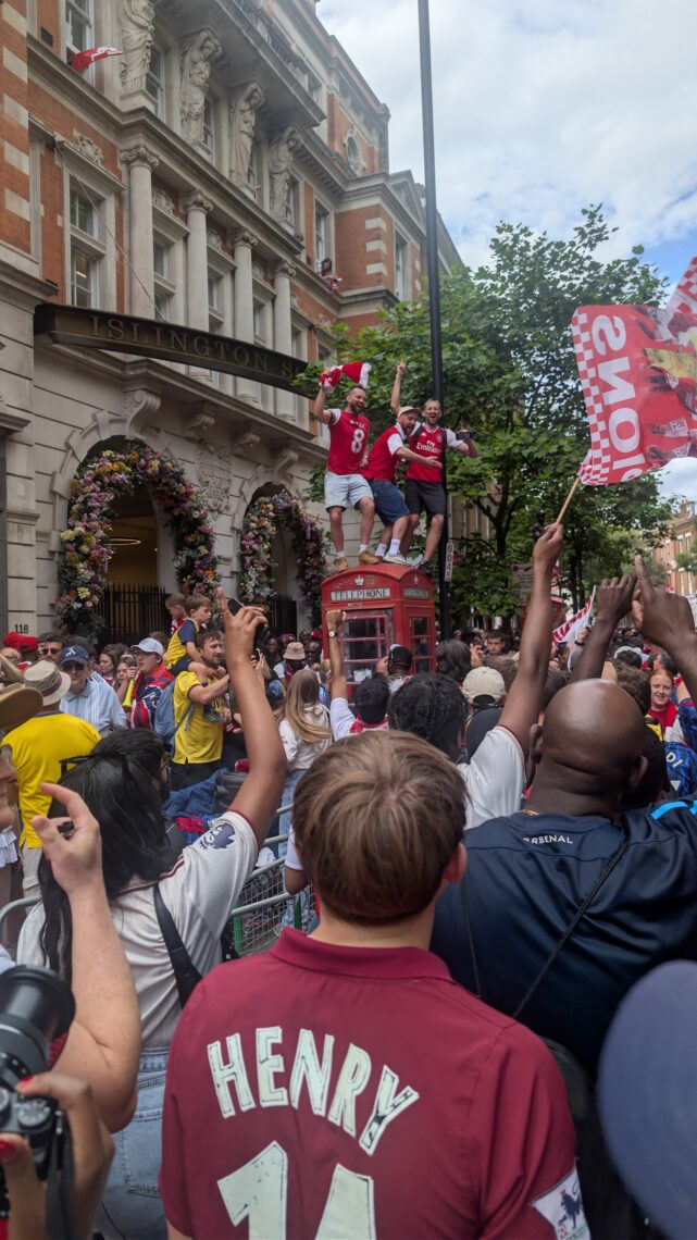 Three lunatics on a phonebox after Arsenal's Champions parade. Upper St, 31 May 2026